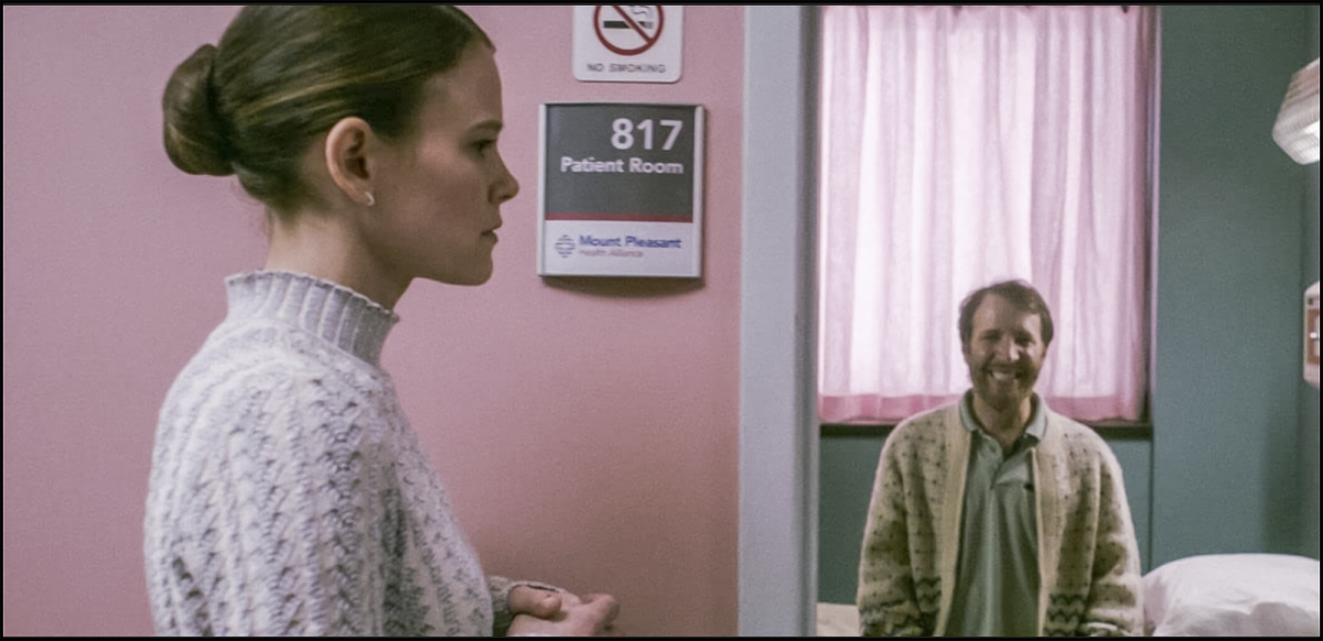 Dr. Rose Cotter, played by Sosie Bacon, attends to a smiling patient. 