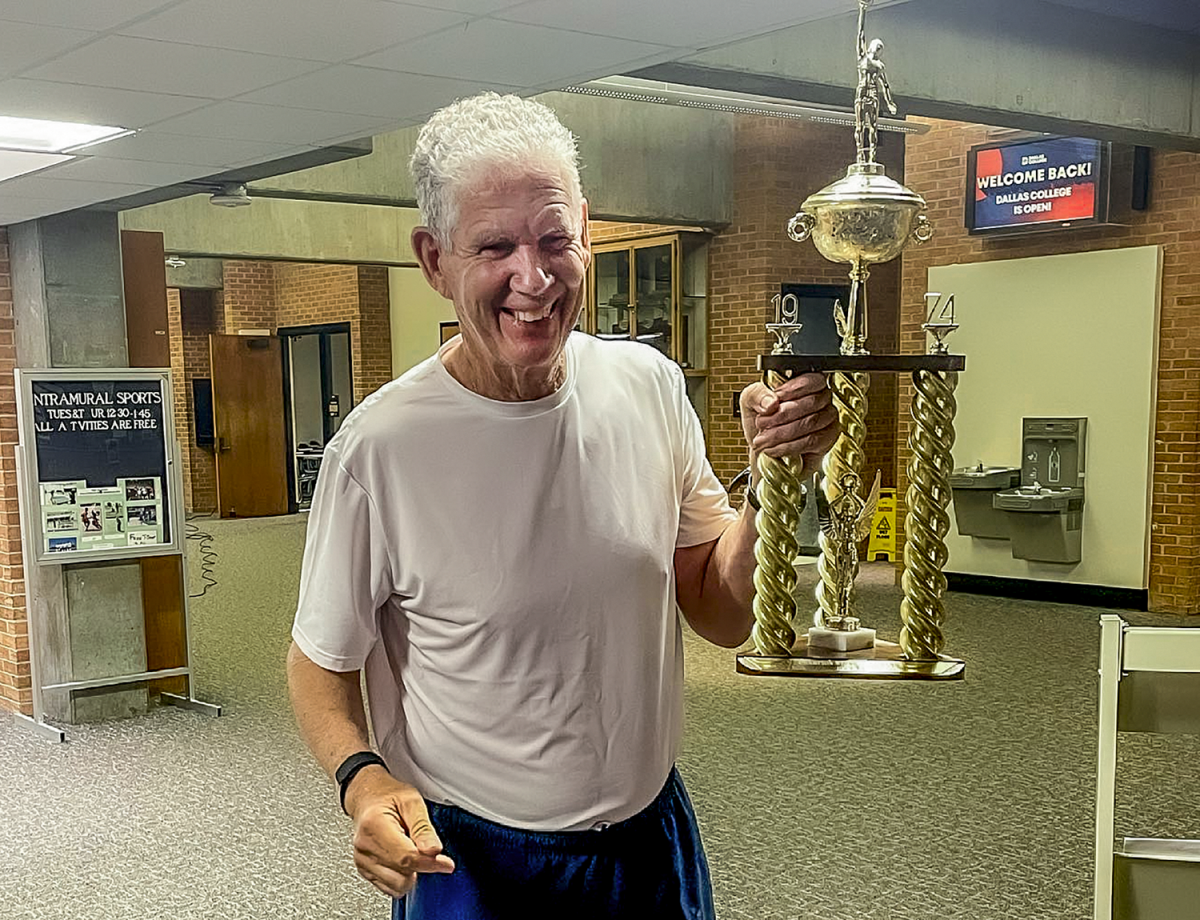 Phil Key in 2021, holding a trophy his team won in 1974.