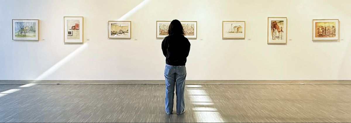 Anh Cao observes newly revealed artwork in the Brazos Gallery’s Unseen Narratives exhibit.