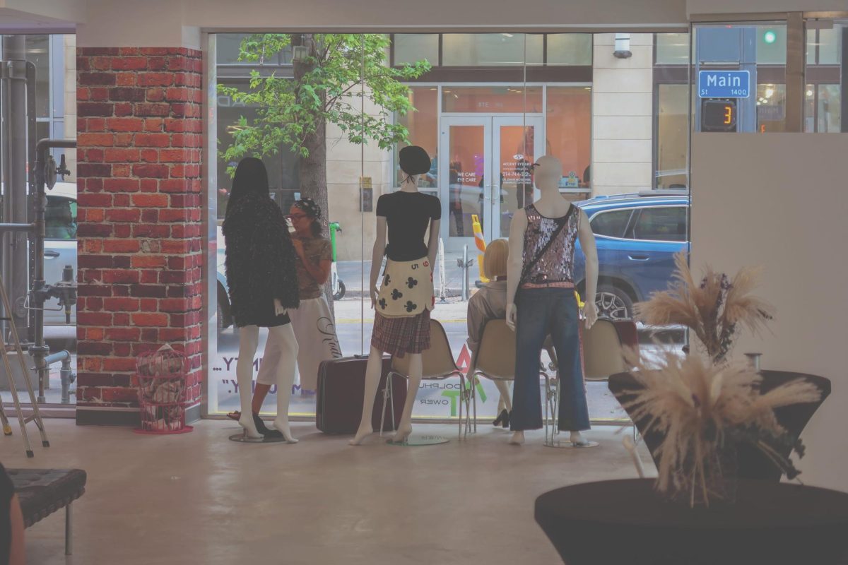 Dallas College student Citlaly Perez adjusts window display for fashion marketing showcase.